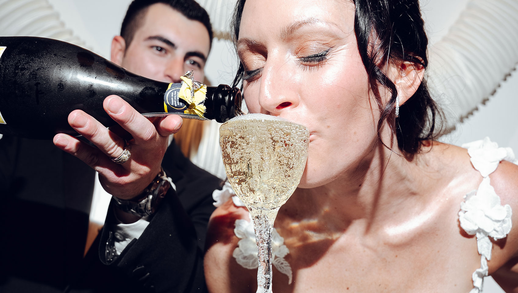 Bride sips from Champagne tower at Kimpton Grand Roatan