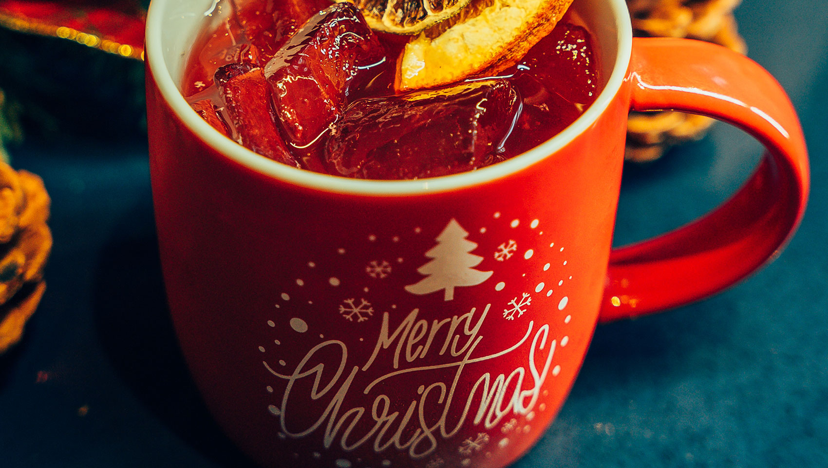 Rum punch in a red holiday mug with an orange garnish