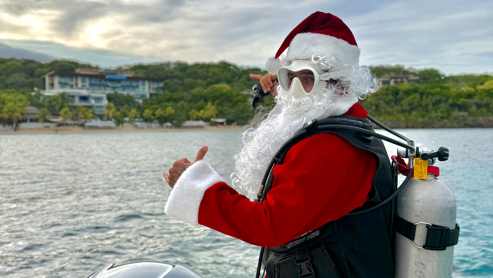santa claus sits in a hammock at Kimpton grand roatan resort and spa