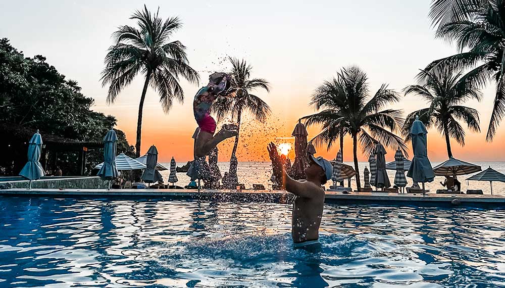 dad tosses child up in pool