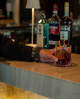 man holding cocktail at bar at Vos Café at Kimpton grand roatan