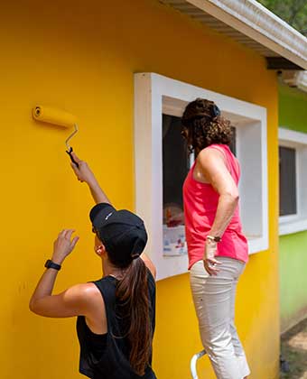 two people painting buillding