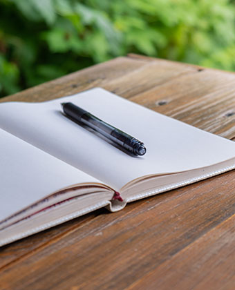 open journal with pen on a wooden table