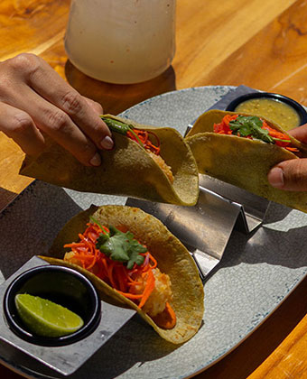 two hands grabbing tacos