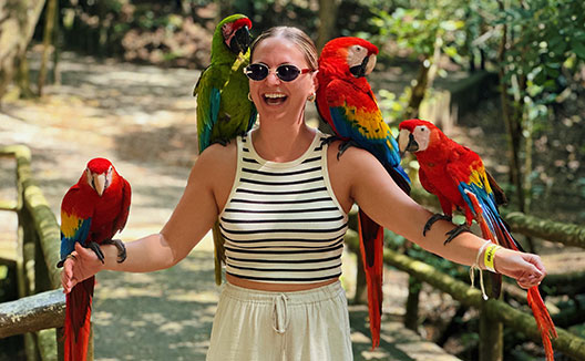 woman with parrots on her shoulders